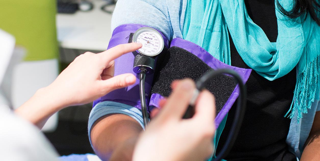 Close-up of a blood pressure measuring sleeve being attached to a patient