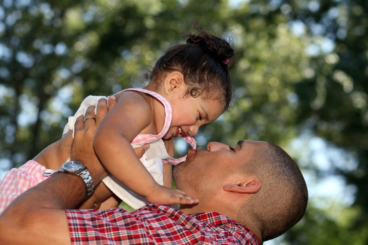 photo of father lifting up daughter