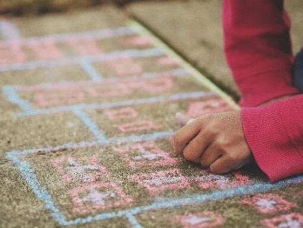 photo of child drawing with chalk