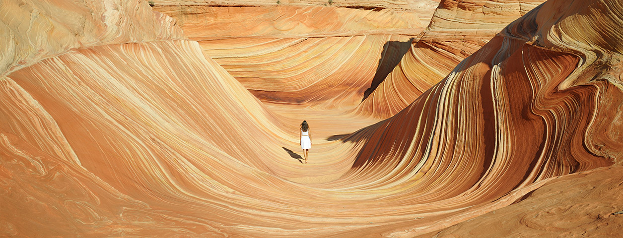 Woman walking down a desert canyon.
