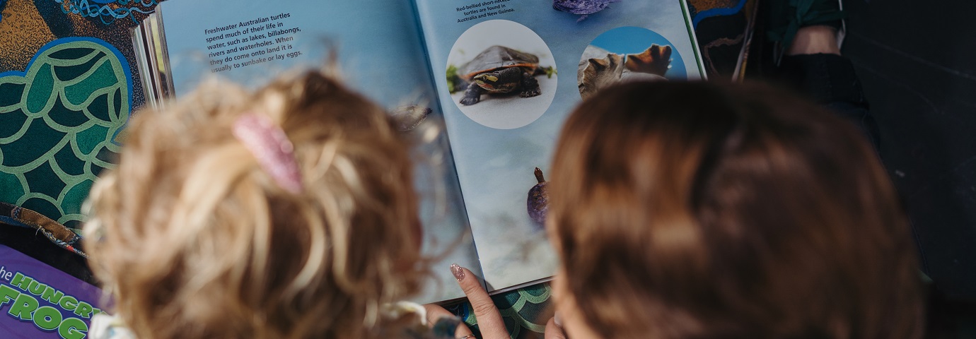 An education student and a child read a picture book together