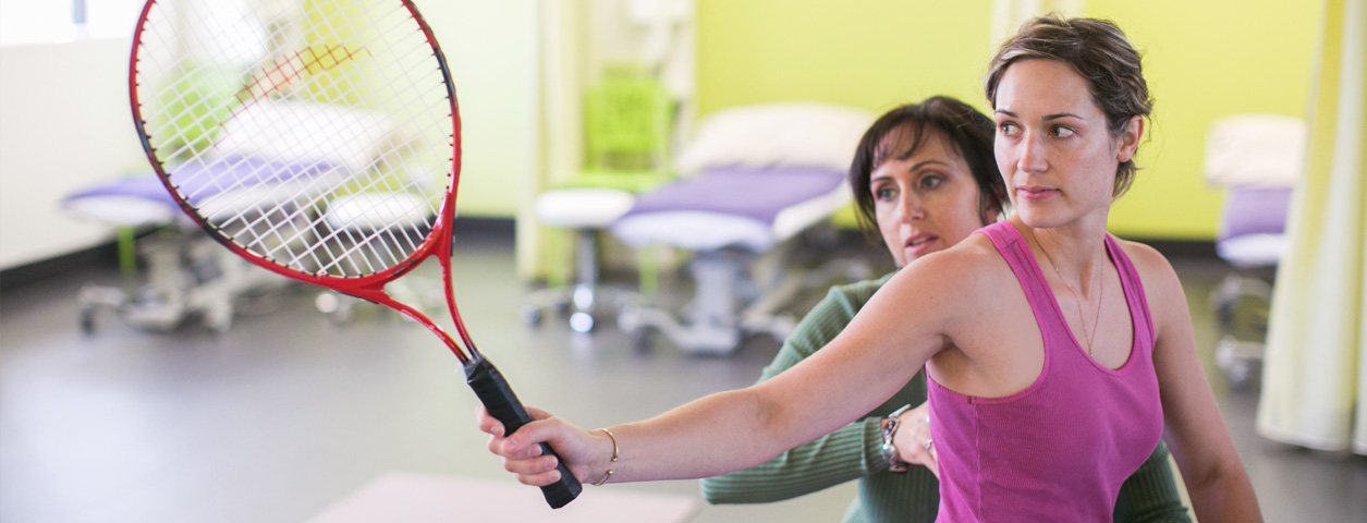 Healthcare and exercise science in practice with patient getting assistance on tennis swing.