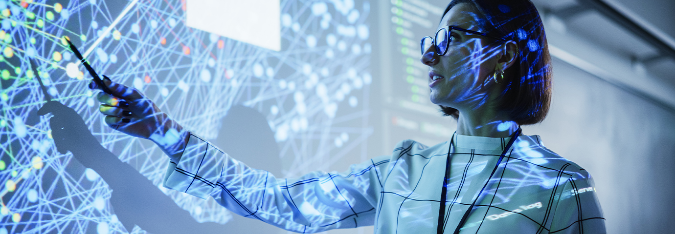 Woman points to a network map projected onto a wall.
