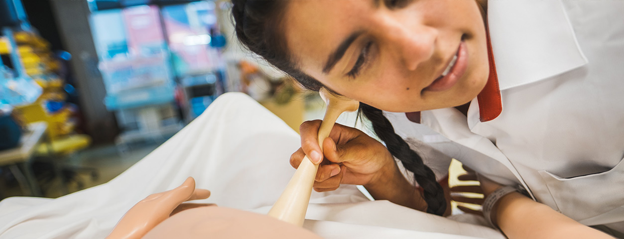 An ACU student simulates a midwifery procedure