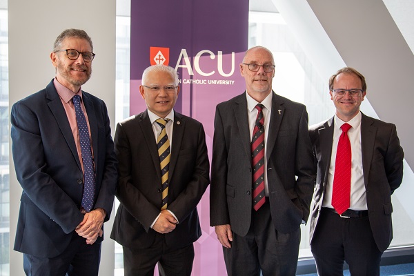 four people standing in front of an ACU sign