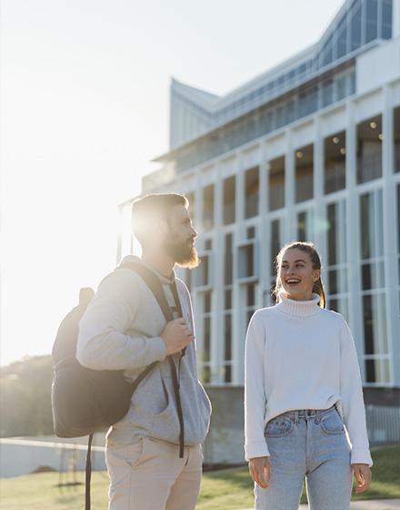 ACU students standing in front of a campus building.