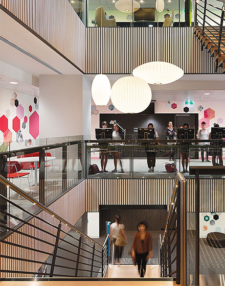 A staircase descends while another ascends, all around are blurs of students moving around.