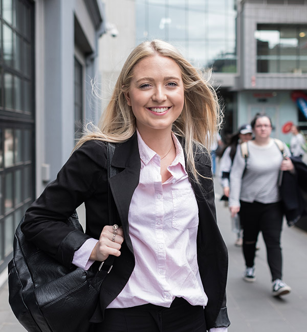 A woman in a suit is smiling