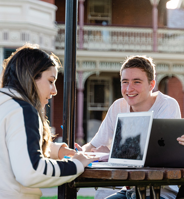 ACU communication students discussing their work on campus
