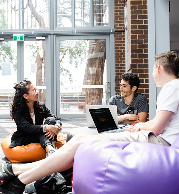ACU economics students sitting in bean bags working on campus
