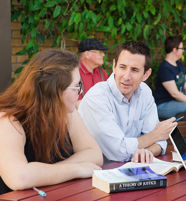 ACU epsitemology and hermeneutics students comparing notes on campus