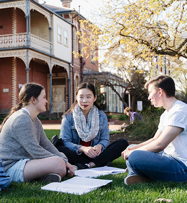 ACU metaphysics students sitting on the grass on campus studying