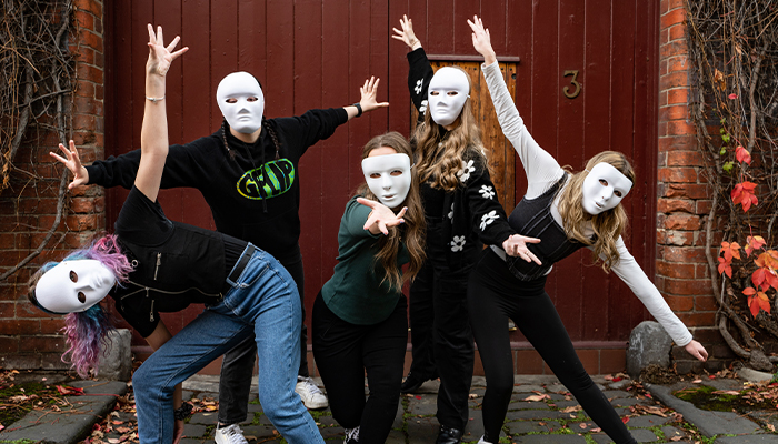 ACU drama students in white face masks pose dramatically