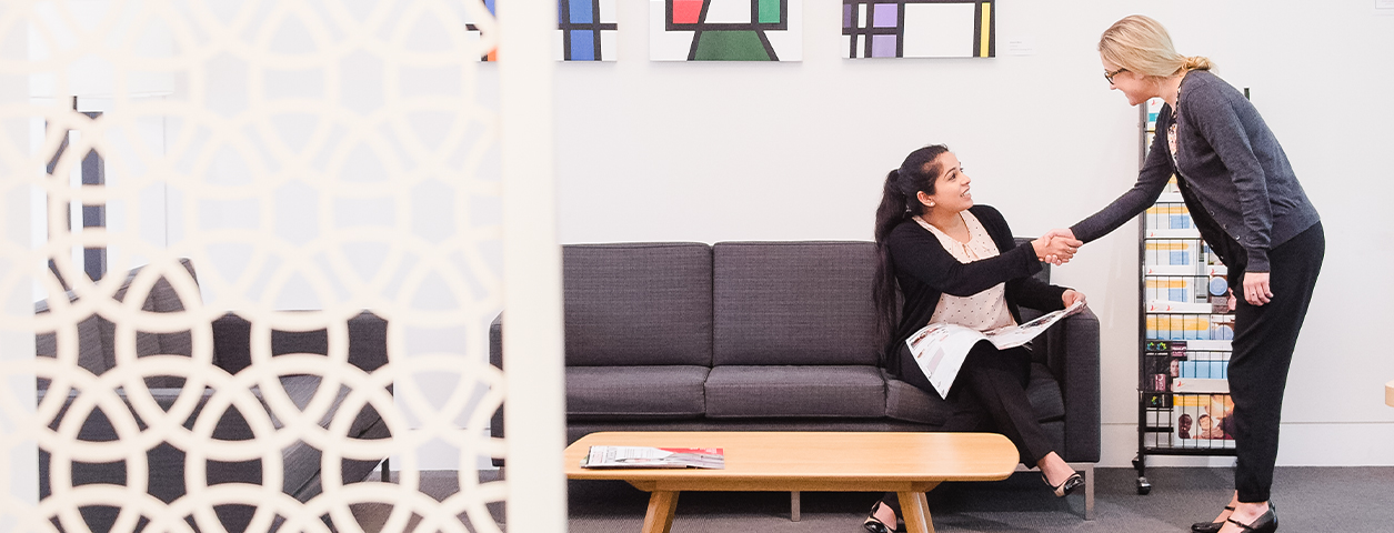 A counsellor welcomes a student to a counselling session.